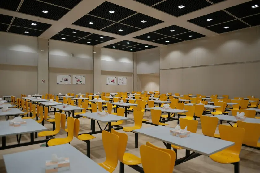 A room filled with lots of tables and yellow chairs